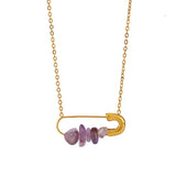 Gold necklace with a safety-pin style pendant featuring amethyst stones.