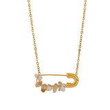 Gold necklace with a safety-pin style pendant featuring citrine stones.